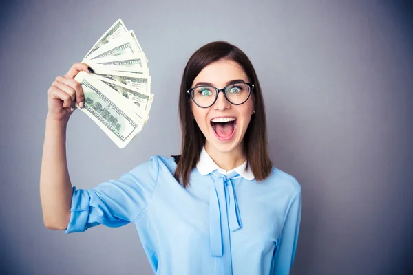 Mujer de negocios sonriente sosteniendo billetes de dólar —  Fotos de Stock