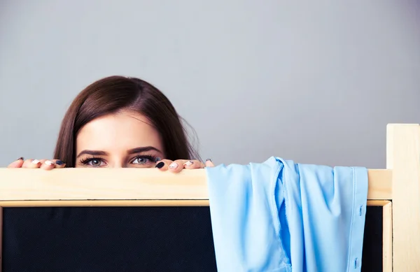 Mujer joven mirando desde el vestuario — Foto de Stock