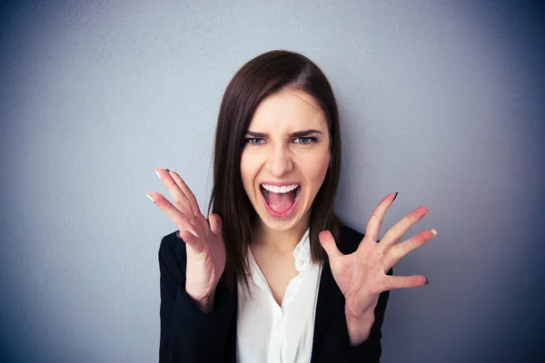 Θυμωμένη γυναίκα, ουρλιάζοντας πέρα από το γκρι φόντο — Φωτογραφία Αρχείου