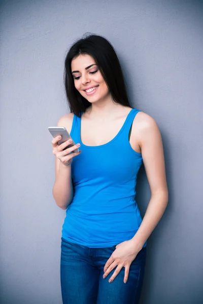 Jovem mulher sorridente usando smartphone — Fotografia de Stock