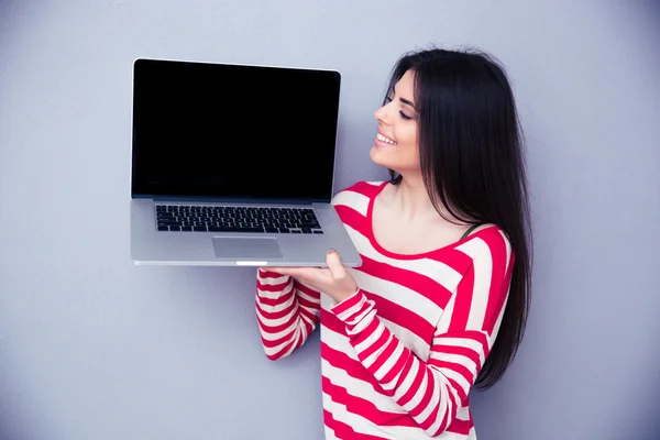 Ευτυχισμένη γυναίκα δείχνει κενός laptop οθόνη — Φωτογραφία Αρχείου