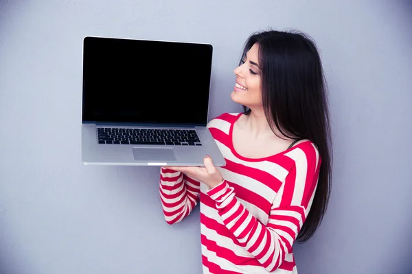 Donna felice mostrando schermo del computer portatile vuoto — Foto Stock