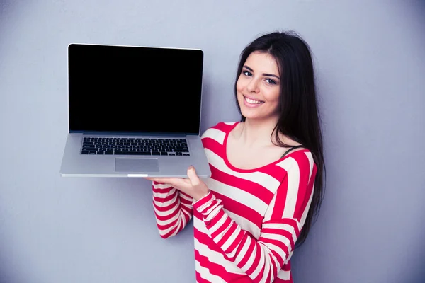 Lächelnde Frau zeigt leeres Laptop-Display — Stockfoto