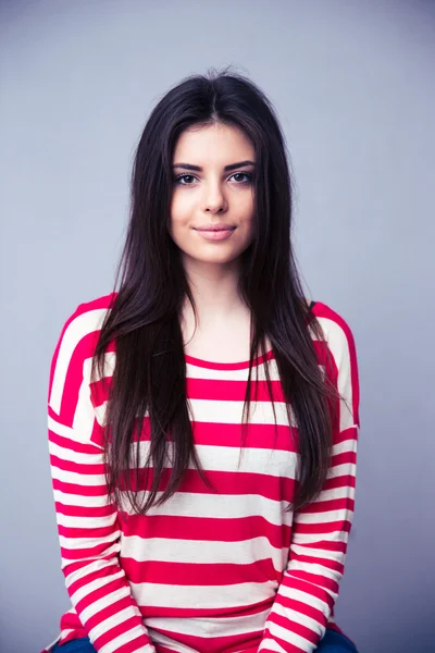 Portrait of a charming young woman over gray background — Stock Photo, Image