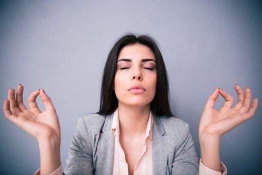 Genç kadın gri arka plan üzerinde meditasyon