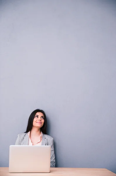 Happy woman sitting at the table with laptop — Stock Photo, Image