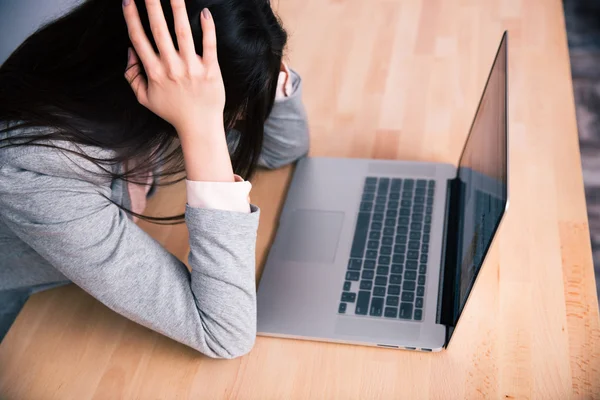 Втомлена бізнес-леді сидить за столом з ноутбуком — стокове фото