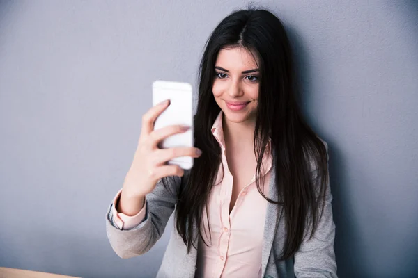 Mujer feliz foto selfie sobre fondo gris —  Fotos de Stock