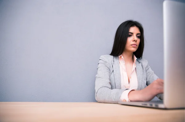 Affärskvinna sitter vid bordet med bärbar dator — Stockfoto