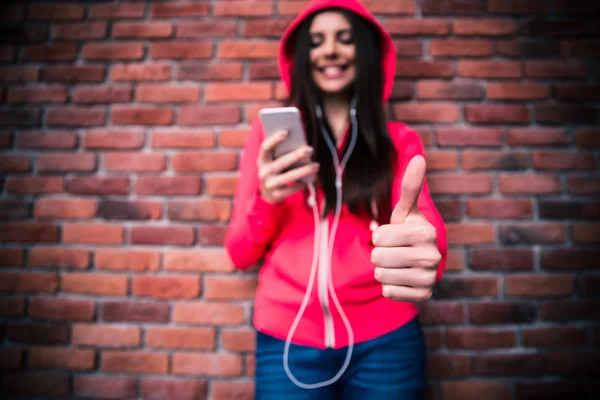 Жінка зі смартфоном показує великий палець вгору — стокове фото