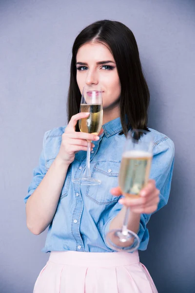 Woman drinking champagne and giving glass at camera — Stock Photo, Image