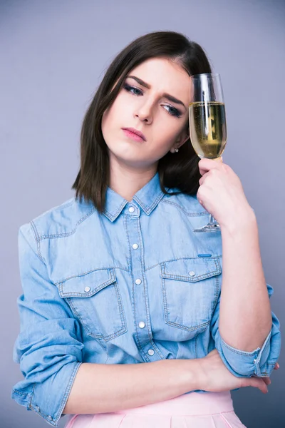 Upset young woman holding glass of champagne — Stock Photo, Image