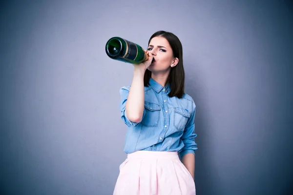 Young woman drinking champagne from a bottle — Stock Photo, Image