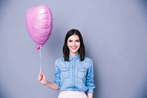 Kadın tutarak balon gülümseyen ve kameraya bakıyor — Stok fotoğraf