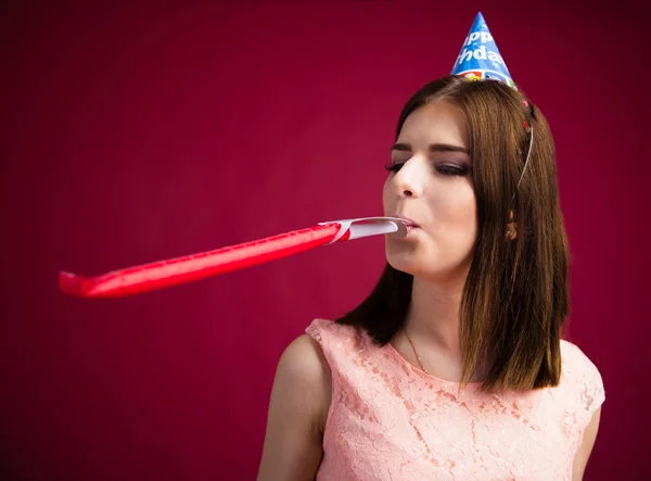 Young woman blowing in party whistle — Stock Photo, Image