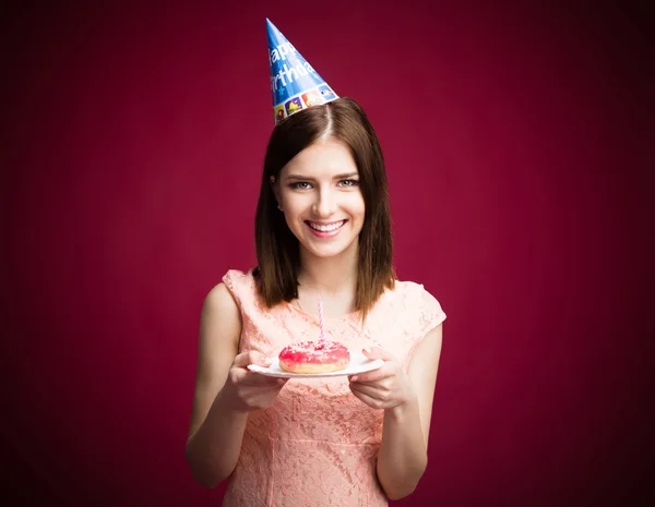 Happy young woman holding donut with candle — Stock Photo, Image