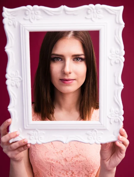 Cute charming woman looking at camera trough frame — Stock Photo, Image