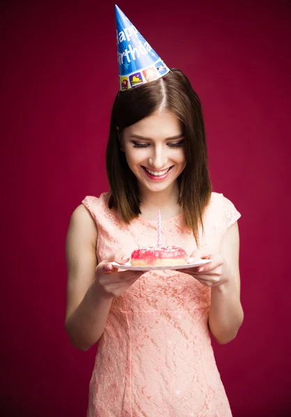 Smling young woman holding donut with candle — Stock Photo, Image