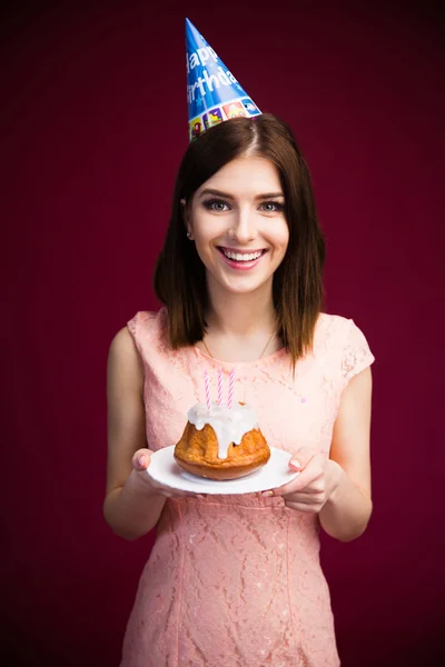 Smiling woman holding cake with candles