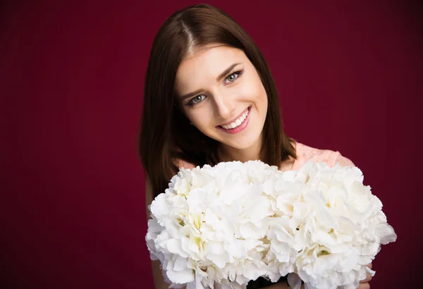 Sonriente hermosa mujer sosteniendo flores —  Fotos de Stock