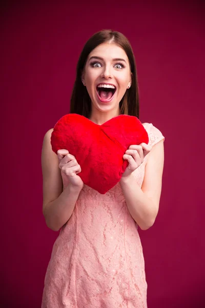 Zaskoczony, kobieta trzyma czerwone serce — Zdjęcie stockowe