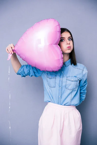 Захищена молода дівчина тримає повітряну кулю у формі серця — стокове фото