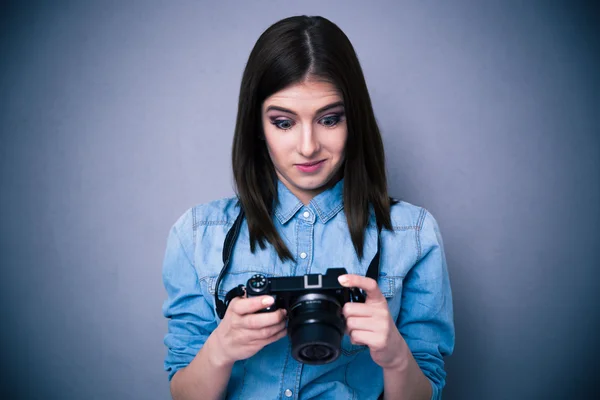 Удивлённая молодая женщина смотрит на экран камеры — стоковое фото