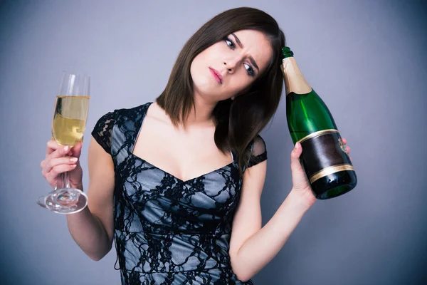 Mujer pensativa sosteniendo dos copas y una botella de champán —  Fotos de Stock