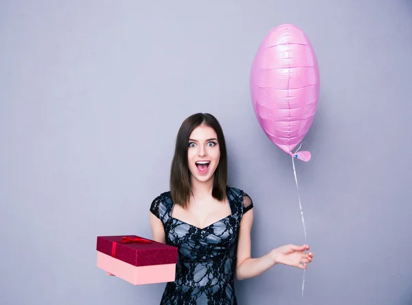 Mujer alegre sosteniendo caja de regalo y globo —  Fotos de Stock
