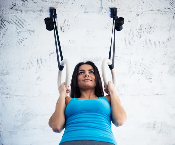 Lykkelig kvinde arbejder ud på gimnastiske ringe - Stock-foto