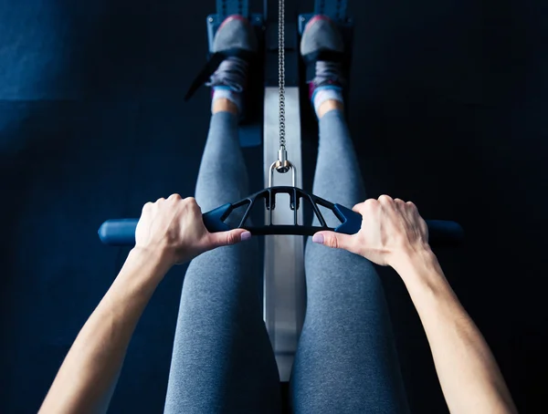 Nahaufnahme einer Frau, die im Fitnessstudio am Simulator trainiert — Stockfoto