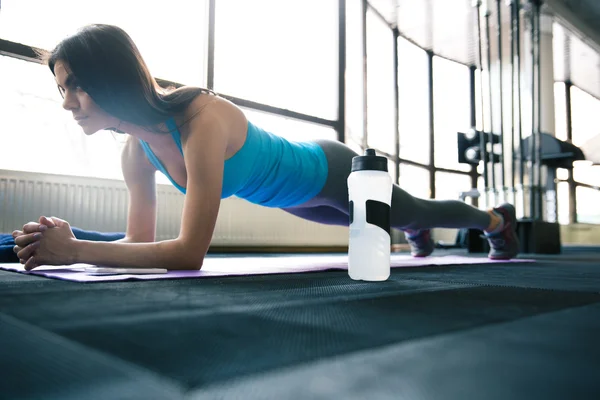 Jeune femme en forme travaillant sur tapis de yoga — Photo