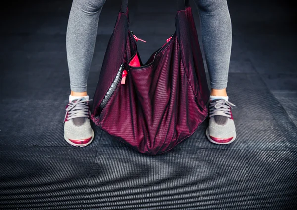 Frauenbeine und Sporttasche — Stockfoto