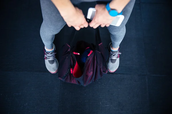 Woman holding fitness bag and smartphone — Stock Photo, Image
