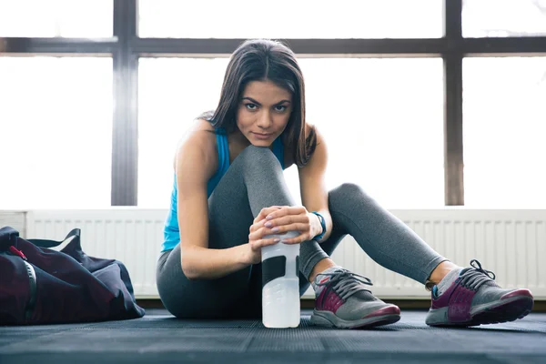 Sportlich schöne junge Frau auf dem Boden sitzend — Stockfoto