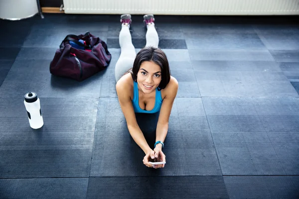 Fitte Frau liegt im Fitnessstudio auf dem Boden — Stockfoto