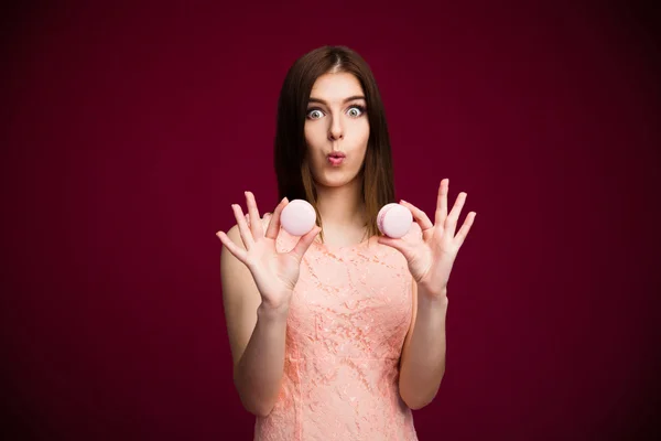 Mujer joven sorprendida sosteniendo galletas — Foto de Stock