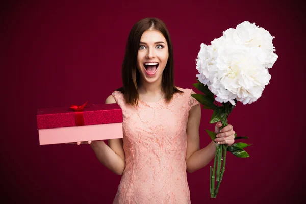 Meglepett, aranyos nő, díszdobozban és virágok — Stock Fotó