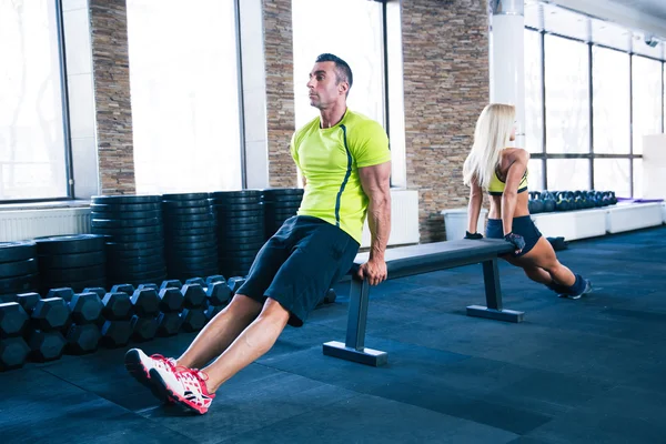 Woman and man workout with hands on bench — Stock Photo, Image