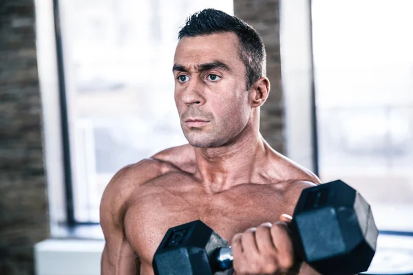 Gespierde man training met dumbbell — Stockfoto