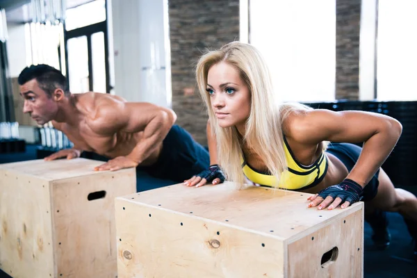 Žena a muž dělá push up v tělocvičně — Stock fotografie