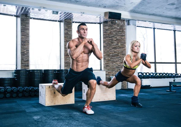 Mujer y hombre haciendo ejercicio en el gimnasio — Foto de Stock