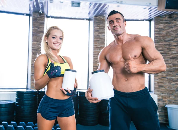 Homem e mulher segurando recipiente com nutrição esportiva — Fotografia de Stock