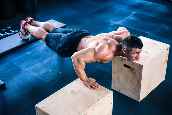 Uomo muscolare che fa flessioni sulla scatola in forma — Foto Stock