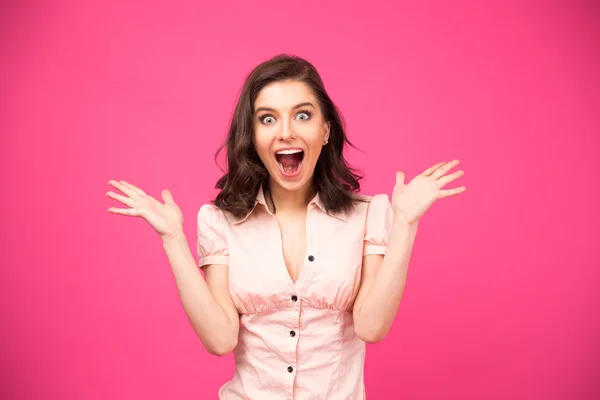 Surprised woman shouting over pink background Stock Picture