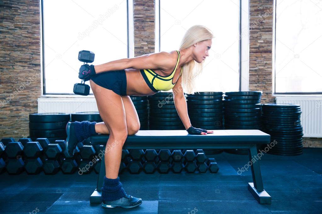 Woman workout with dumbbell on the bench