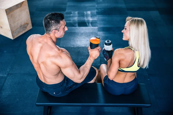 Frau und Mann sitzen im Fitnessstudio auf der Bank — Stockfoto
