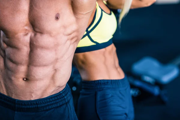 Muscular man's and strong woman's torso — Stock Photo, Image