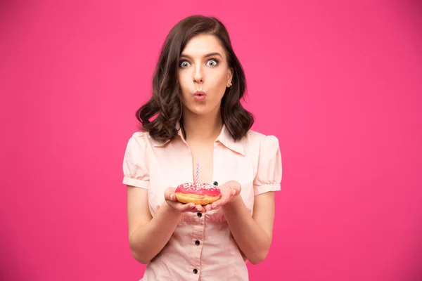 Junge Frau hält Donut mit Kerze — Stockfoto