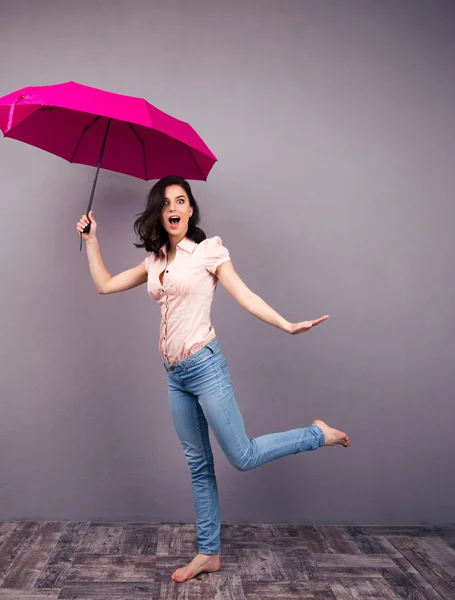 Удивлённая женщина позирует с зонтиком — стоковое фото